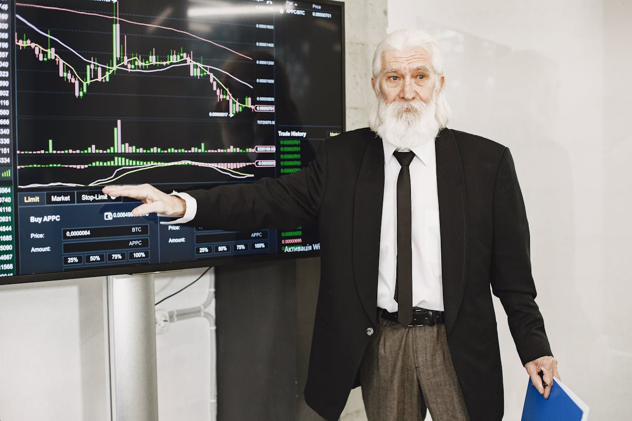 Senior businessman presenting stock market analysis with a chart display in a corporate setting.